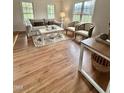 Bright living room with wood floors, neutral decor, and plenty of natural light from large windows at 723 Whitt Town Rd Rd, Roxboro, NC 27574