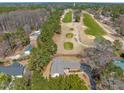 An aerial view of a charming home adjacent to a lush green golf course with mature trees at 7516 Mourning Dove Dr, Sanford, NC 27332