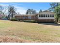 Expansive backyard featuring a spacious deck, brick accents, and a well-maintained lawn at 7516 Mourning Dove Dr, Sanford, NC 27332