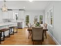Bright dining room with hardwood floors, large windows, and a view to the outdoor patio at 8304 Circlewood Ct, Raleigh, NC 27615