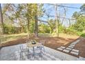 Outdoor dining area in the backyard surrounded by trees provides a secluded relaxation space at 101 Newell St, Durham, NC 27705
