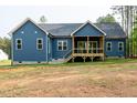 Back exterior of blue home with covered wood deck and large backyard at 110 Purslane Dr, Franklinton, NC 27525