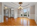 Bright dining room with hardwood floors, chandelier, and ample natural light from large bay windows at 113 Kings Castle Dr, Apex, NC 27502