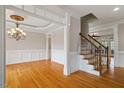 An open-concept foyer with gleaming hardwood floors features a staircase and decorative chandelier at 113 Kings Castle Dr, Apex, NC 27502