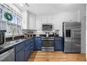 Contemporary kitchen featuring navy blue cabinets and stainless steel appliances at 1303 Dylan Heath Ct, Raleigh, NC 27608