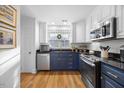 Modern kitchen with navy cabinets, stainless steel appliances, and hardwood flooring at 1303 Dylan Heath Ct, Raleigh, NC 27608