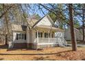 View of the home's front exterior featuring a cozy front porch, and a brick foundation at 138 Sherwood Ln, Sanford, NC 27332