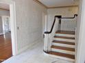 Foyer features marble floors and a wooden staircase, creating an elegant entry to the home at 1703 St. Mary'S St, Raleigh, NC 27608