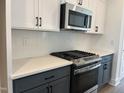 Modern kitchen featuring stainless steel appliances, white backsplash, and sleek gray cabinets at 1919 Plott Balsam Dr, Wendell, NC 27591