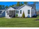 Back exterior with a well-maintained lawn, screened porch, and lush landscaping at 271 Sacred Fire Rd, Louisburg, NC 27549