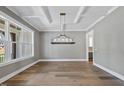 Bright dining room with modern light fixture, coffered ceilings, and hardwood floors at 2829 Theresa Eileen Way, Raleigh, NC 27603