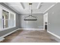 Spacious dining room with coffered ceiling, contemporary lighting, and large windows for ample natural light at 2829 Theresa Eileen Way, Raleigh, NC 27603
