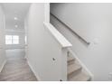 Bright entryway featuring carpeted stairs, wood-look flooring, and white walls at 2834 Egert Dr, Haw River, NC 27258