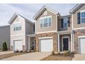 Townhome with tan siding, brick accents, a one-car garage, and a covered front entryway at 2834 Egert Dr, Haw River, NC 27258