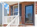 Inviting front porch showcasing brickwork, white railings, and a stylish front door with glass detail at 3007 Cardinal Lake Dr, Durham, NC 27704