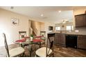 Dining area featuring a round glass table with four chairs and an adjacent kitchen at 303 Fortress Dr, Morrisville, NC 27560
