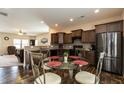 Well-lit kitchen with dark cabinets, stainless steel appliances, and a glass top dining table at 303 Fortress Dr, Morrisville, NC 27560