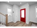 Bright foyer featuring beautiful hardwood floors and a vibrant red front door at 305 Wash Hollow Dr, Wendell, NC 27591