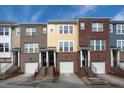 Attractive townhome exterior featuring mixed brick and siding, individual entrances, and convenient garage access at 317 Michigan Ave, Cary, NC 27519