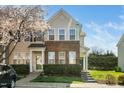 Charming townhome with brick accents, green door, and blossoming tree at 3615 Ramblewood Ave, Durham, NC 27713