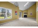 Bright living room featuring vaulted ceilings, fireplace, skylight, and sliding glass doors to the patio at 4 Applewood Sq, Durham, NC 27713