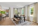 Bright dining room with wood floors, table, and bench seating near the kitchen at 4706 Cypress Tree Ln, Raleigh, NC 27612