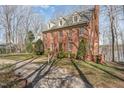 Beautiful exterior elevation of this brick home features mature trees and a manicured lawn at 4808 Clubview Ct, Fuquay Varina, NC 27526