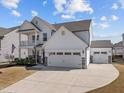 Side view of a home with a two-car garage and a separate one-car garage, with a large concrete driveway at 518 Hampton Crest Ct, Fuquay Varina, NC 27526