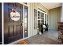 Inviting front porch with welcome decor, a bench, and decorative stone accents, complemented by a window and shutter at 6720 Colleen Rd, Rocky Mount, NC 27803