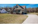 Side view of home featuring neutral siding, garage, and driveway with basketball hoop on expansive lawn at 6720 Colleen Rd, Rocky Mount, NC 27803