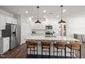 Well-lit kitchen featuring white cabinetry, stainless steel appliances, granite counters, and an island with bar stools at 780 Ben Ledi Ct, Raleigh, NC 27603