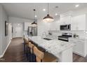 Modern kitchen featuring stainless steel appliances, pendant lighting, and a spacious island with breakfast bar seating at 780 Ben Ledi Ct, Raleigh, NC 27603