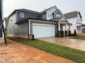 Side view of a well-built two-story home with a two-car garage, showing its durable siding at 789 Old Station Pointe, Angier, NC 27501