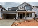 Gray two-story home with attached two-car garage, covered porch, and landscaped yard at 789 Old Station Pointe, Angier, NC 27501