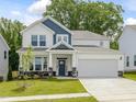 Beautiful two-story home with blue accents, a well-manicured lawn, and a two-car garage at 789 Old Station Pointe, Angier, NC 27501