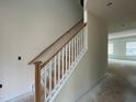 Staircase with light wood handrail and white risers leads to the second floor at 789 Old Station Pointe, Angier, NC 27501