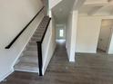 View of the carpeted staircase with dark wood handrail and white risers leading to the upper level at 789 Old Station Pointe, Angier, NC 27501