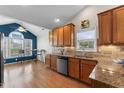 Bright kitchen featuring wood cabinets, stainless steel appliances, and a cozy breakfast nook with large windows at 832 Cabin Branch Dr, Fuquay Varina, NC 27526