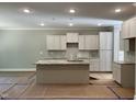 New kitchen with recessed lighting, an island with granite countertops, and white cabinets at 977 Lewis Rd, Zebulon, NC 27597