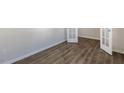 Spacious room featuring new flooring and attractive, light-filled french doors at 105 Pisgah St, Sanford, NC 27330