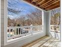 Relaxing balcony with wood decking and white railing overlooks the yard at 1051 Wirewood Dr # 202, Raleigh, NC 27605