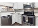 Bright kitchen with stainless steel appliances, white cabinets and countertops at 1051 Wirewood Dr # 202, Raleigh, NC 27605
