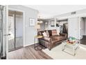 Inviting living room features hardwood floors, neutral paint and a comfortable leather sofa at 1051 Wirewood Dr # 202, Raleigh, NC 27605