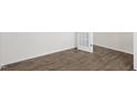 Bright bedroom showcasing wood-look flooring, white trim, white walls, and a stylish, glass paneled door at 108 Pisgah St, Sanford, NC 27330