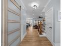 Hallway with wood floors, wood-trimmed doorways, and a view to an open floor plan at 110 Black Swan Dr, Youngsville, NC 27596