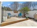 Charming patio with wooden deck, seating, lush greenery, privacy fence, and outdoor dining area at 1104 Garnet Ridge Way, Raleigh, NC 27607