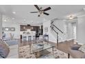 Open-concept living space featuring hardwood floors, a ceiling fan, and a staircase to the second floor at 1160 Craigmeade Dr, Morrisville, NC 27560