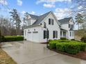 Exterior view of the white home with attached garage, featuring well-maintained landscaping and a basketball hoop at 1188 The Preserve Trl, Chapel Hill, NC 27517