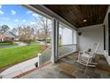 Covered front porch with slate flooring, white rocking chairs, and a view of the landscaped front yard at 1188 The Preserve Trl, Chapel Hill, NC 27517