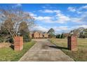 Long driveway leading to a charming brick home, framed by brick pillars and lush greenery at 1220 Bethlehem Rd, Knightdale, NC 27545